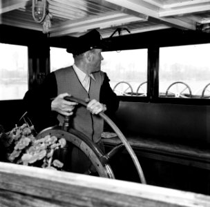 Schipper Anton Rieb aan het roer van de Damco 9, vermoedelijk in West- Duitsland, Bestanddeelnr 254-1352