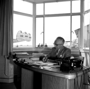 Schiphol-directeur Jan Dellaert aan zijn bureau op de luchthaven. Op de achtergr, Bestanddeelnr 254-2465