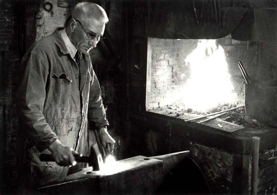Smid Moolenaars in zijn smederij aan de Baljuwslaan te Haarlem afbeelding door C.de Boer. - ca.1978. - 1 foto zwart-wit 12,6x17,8 cm. Afgebeeld is smid Moolenaars van de firma vh Gebr.W.Mool, NL-HlmNHA 54010752