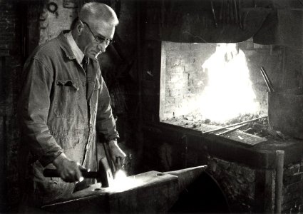 Smid Moolenaars in zijn smederij aan de Baljuwslaan te Haarlem afbeelding door C.de Boer. - ca.1978. - 1 foto zwart-wit 12,6x17,8 cm. Afgebeeld is smid Moolenaars van de firma vh Gebr.W.Mool, NL-HlmNHA 54010752