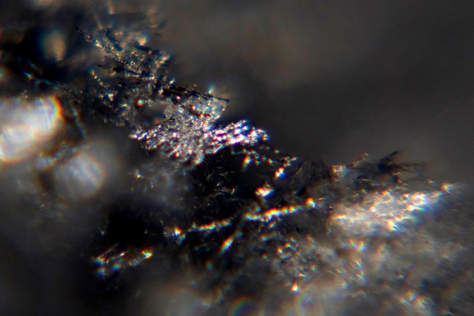 Snow crystals glittering in strong direct sunlight 38 - cropped - high contrast