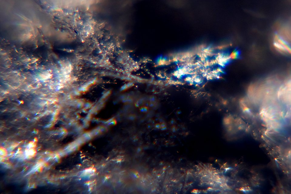 Snow crystals glittering in strong direct sunlight 45 - cropped - high contrast