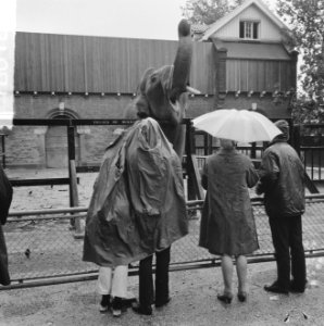 Slecht weer, mensen in regenkleding gehuld bij de olifant, Bestanddeelnr 918-0180