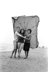 Slecht weer in het weekend. Dames met parasol maken strandwandeling, Bestanddeelnr 915-3398