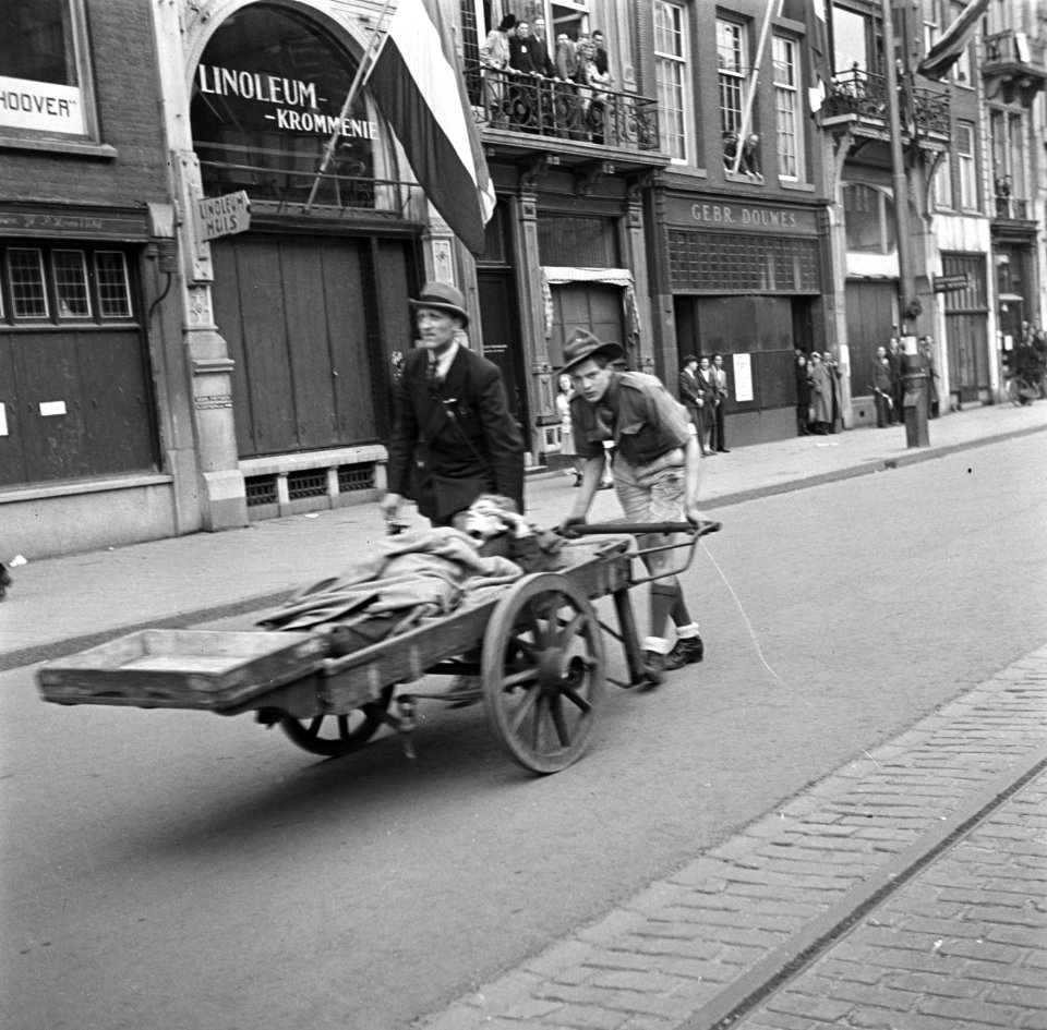 Slachtoffer van Duits mitrailleurvuur vanuit de Groote Club op de Dam wordt door, Bestanddeelnr 900-2947