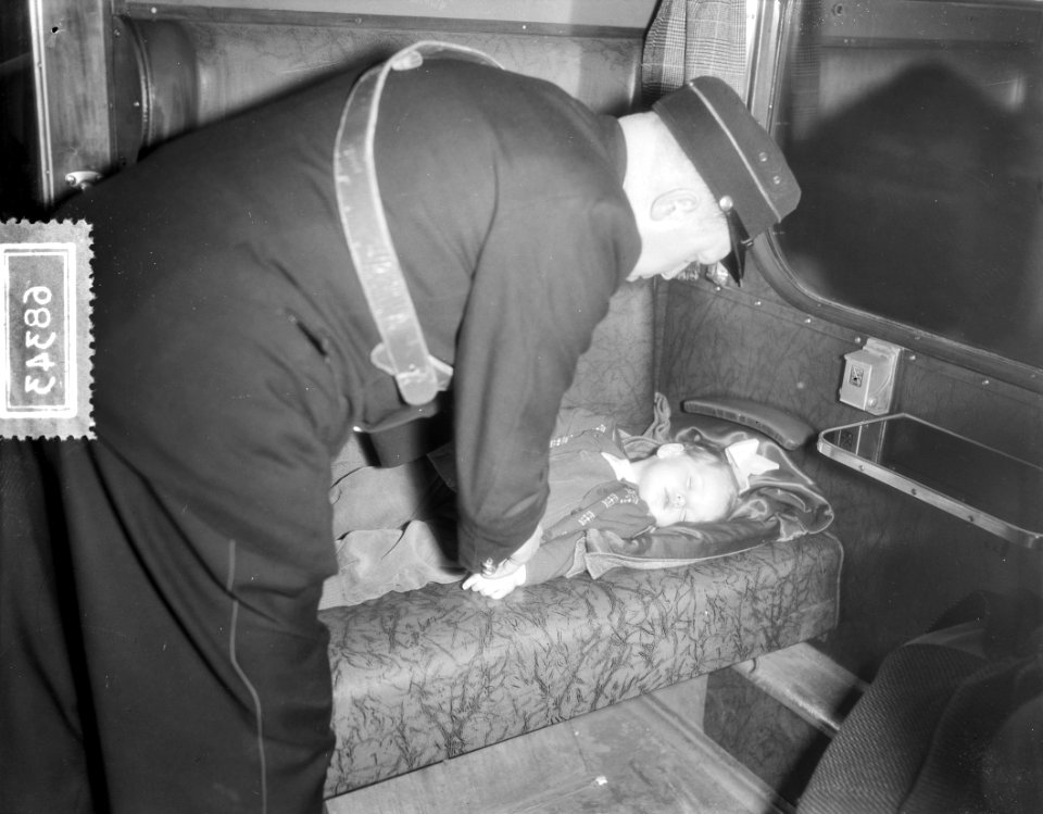 Slapend kind met conducteur in trein, Bestanddeelnr 906-8343