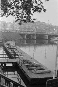 Slapende toeristen op de steiger voor het CS Amsterdam, Bestanddeelnr 933-3848