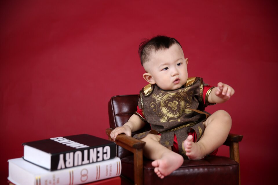 King boy sitting in a chair on the boy