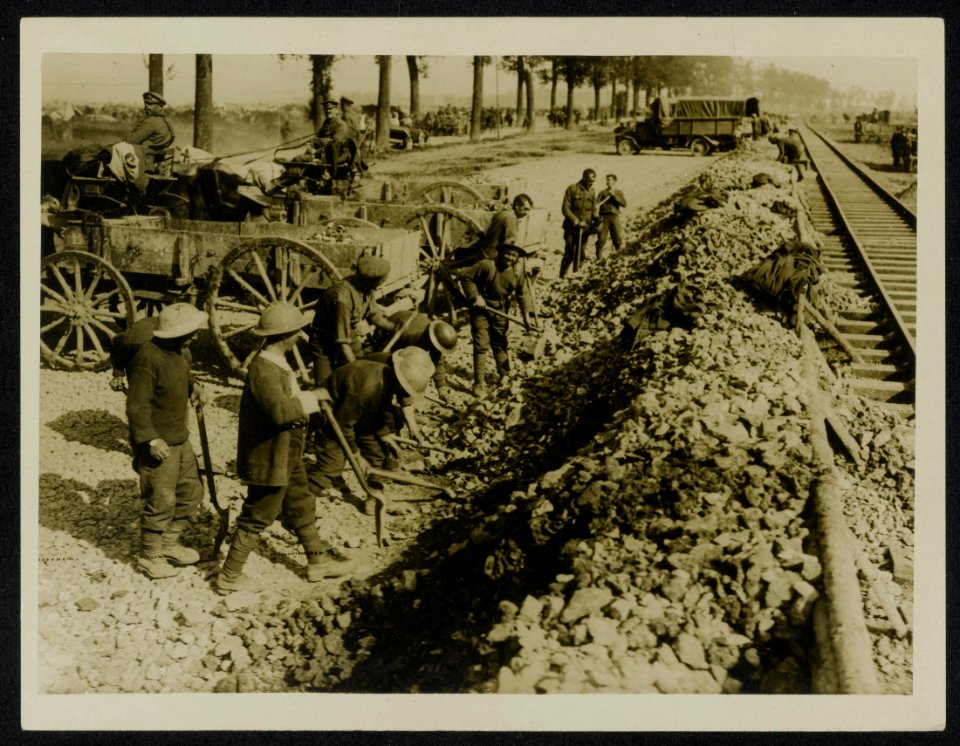 Some men of the Navvy Battalion at work loading stones to make roads, Bestanddeelnr 158-0434