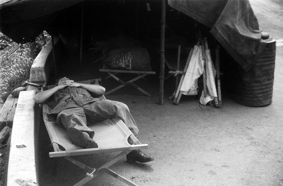 Soldaat slaapt op een veldbed voor een tent, Bestanddeelnr 6702