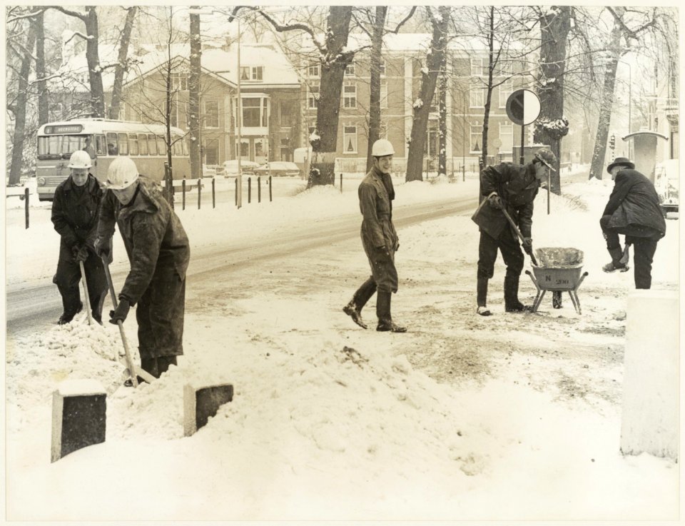 Sneeuwruimen door de Gemeentelijke Reinigingsdienst op de Kleine Houtweg bij de ingang van de Mariastichting ziende naar het Noorden. NL-HlmNHA 54011640