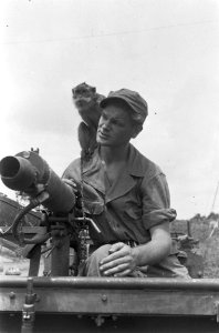 Soldaat zit achter een Vickers mitrailleur in een jeep met een aap op zijn schou, Bestanddeelnr 6161