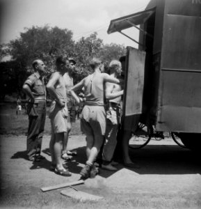 Soldaten verzamelen zich bij de ingang van de truck van de Dienst Welfare, Bestanddeelnr 11335