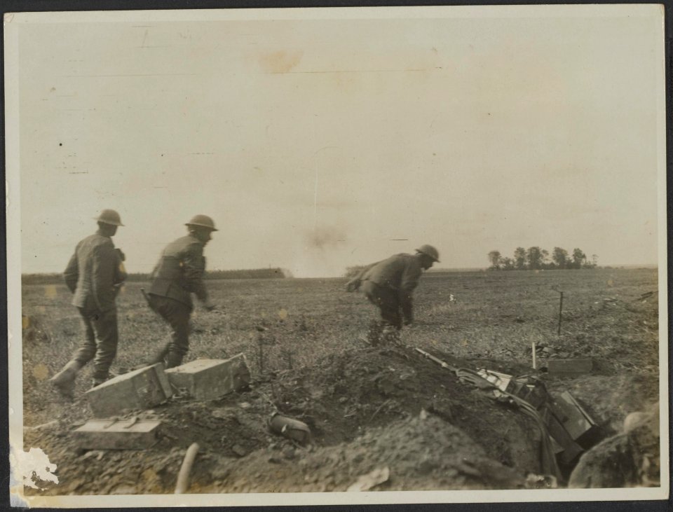 Soldaten trekken op bij een loopgraaf terwijl verderop bommen inslaan, Bestanddeelnr 158-2414