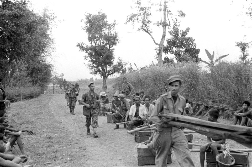 Soerabaja-sector. De dragers zitten op de grond met hun lading, terwijl de solda, Bestanddeelnr 4621
