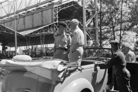 Soerabaja. Dr. C.P.M. Romme, in licht overhemd, staand in een open auto met een…, Bestanddeelnr 137-2-5
