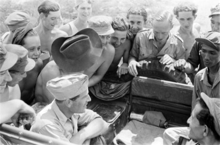 Soldaten scharen zich lachend om een geuniformeerde man, Bestanddeelnr 30-4-5