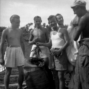 Soldaten met ontbloot bovenlijf staan bij een zak Een van de mannen houdt een , Bestanddeelnr 13054