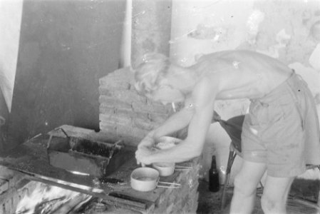 Soldaat bezig met koken op een geimproviseerd fornuis (barbecue), Bestanddeelnr 229-4-3