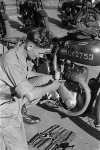 Soldaat bezig met onderhoud van motorfiets, Bestanddeelnr 211-4-4