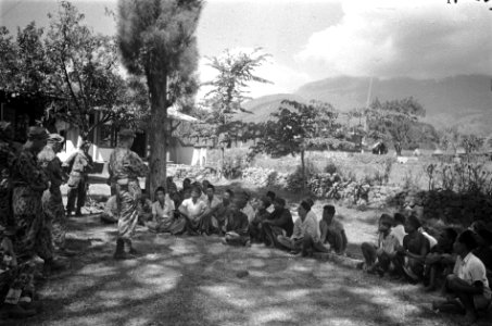 Soerabja-sector Indonesische mannen en jongens zitten op de grond en worden toe, Bestanddeelnr 4629