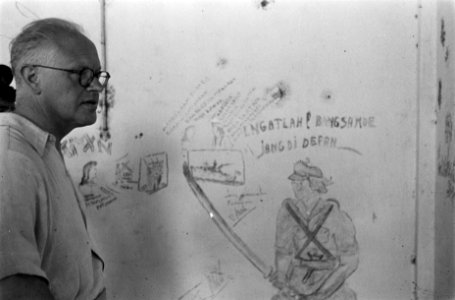 Soerabaja sector. Dr. C.P.M. Romme bekijkt Indonesische strijdkreten op een muur, Bestanddeelnr 137-1-5