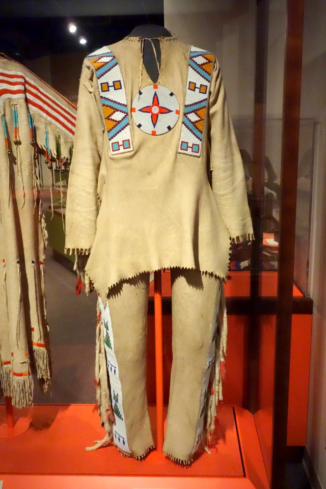 Shirt and leggings, Tsuu T'ina, 1890s, hide, weasel tails, feathers, glass beads, brass - Glenbow Museum - DSC00848