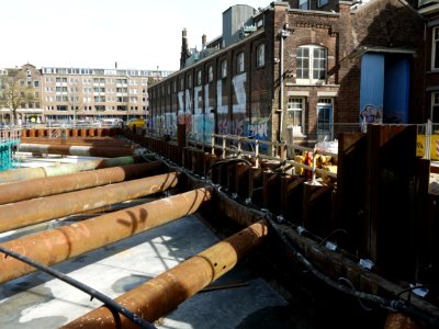 Sheet piling and rusty construction tubes around the large excavation concrete - in Amsterdam-West - Bouwput voor De Hallen, Kinkerbuurt amsterdam