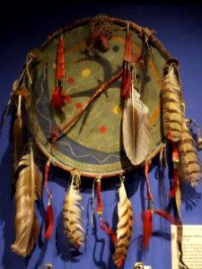 Shield with thunderbird and moon designs, Sioux, late 19th century, hide over wooden hoop with feathers, horse hair, porcupine quills, metal cones - Glenbow Museum - DSC00733