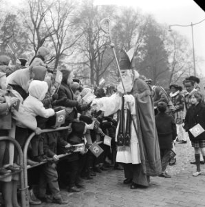 Sinterklaas terwijl hij een kind uit het publiek de hand schudt, Bestanddeelnr 918-4738