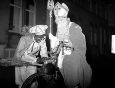 Sint Nicolaas en Zwarte Piet per bromfiets op weg naar het schaaktoernooi in de , Bestanddeelnr 904-3095