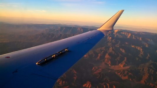 Spoilers on an American Eagle CRJ jet Note airplane flying in distance below