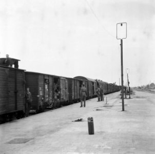Spoorwegstation met gereedstaande goederenwagons waarin passagiers, Bestanddeelnr 900-5061