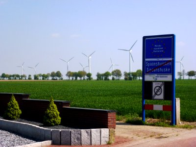 Spaanshuisken grensplaat en zicht op windmolenpark in Duitsland