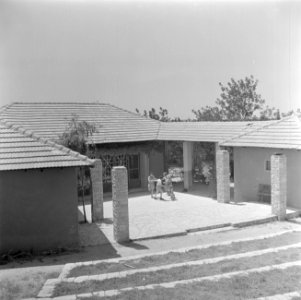 Spelende kinderen op de binnenplaats van een moderne bungalow in (vermoedelijk) , Bestanddeelnr 255-0636