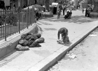 Spelend jongetje en slapende zwerver op straat, Bestanddeelnr 191-0137