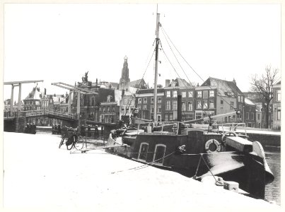 Spaarne bij de Bakenessergracht, ziende naar het Westen. Gravestenenbrug, Waag, Teylers museum. NL-HlmNHA 54010649