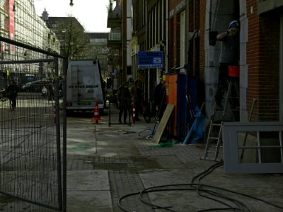 Street scene of Amsterdam-West with buidling fences near Kinkerstraat in Amsterdam Oud-West - Dagelijkse straat-scene, met bouwhekken in Amsterdam Oud-West van de Tollensstraat die de Kinkerstraat kruist