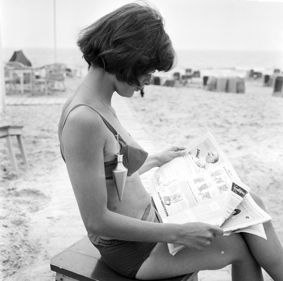 Strandmode 1964, jonge dame draagt het nieuwe snufje op gebied van zonnebrandoli, Bestanddeelnr 916-4556
