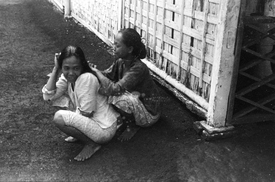 Straatbeelden Twee jonge vrouwen, waarvan de achterste het haar van de voorste , Bestanddeelnr 3469