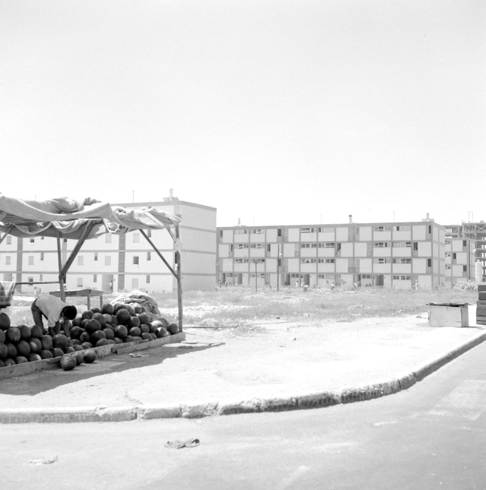 Straat met nieuwbouwflats op de voorgrond links een meloenenverkoper, Bestanddeelnr 255-2976