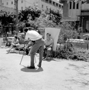 Straatfotograaf is een portretopname aan het maken van een jongeman, Bestanddeelnr 255-1837