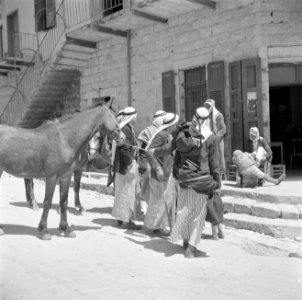 Straatbeeld in Nazareth met arabieren en muilezels. Links tegen de gevel van een, Bestanddeelnr 255-1032