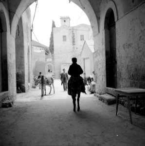 Straat met voorbijgangers en ezels gezien vanonder een poort, Bestanddeelnr 255-3255 photo