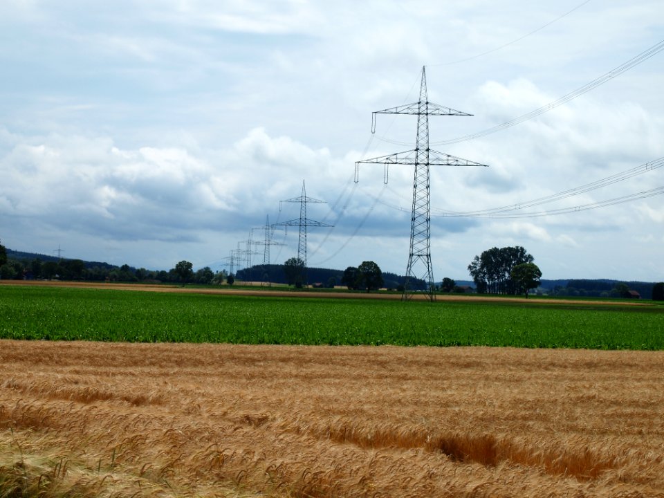 Strommast mit Kornfeld und Wolken