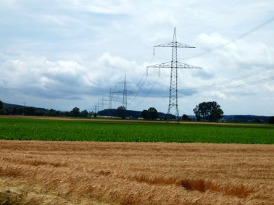 Strommast mit Kornfeld und Wolken