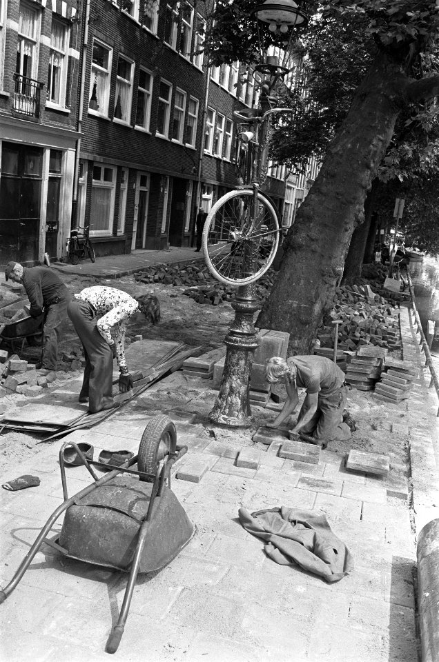 Stratenmakers hebben een fiets in een lantaarnpaal gehangen om door te kunnen we, Bestanddeelnr 928-0003