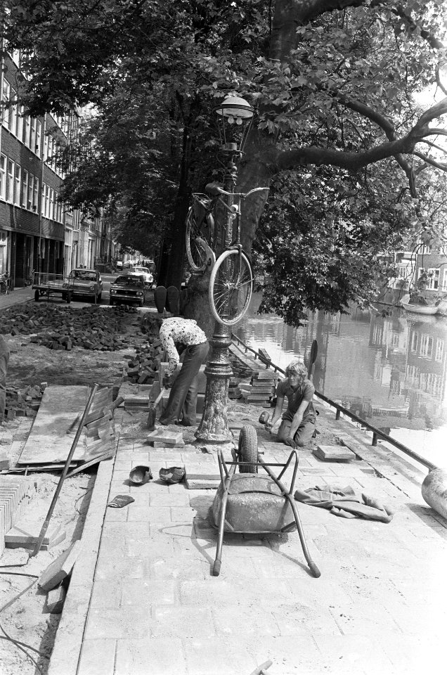 Stratenmakers hebben een fiets in een lantaarnpaal gehangen om door te kunnen we, Bestanddeelnr 928-0002