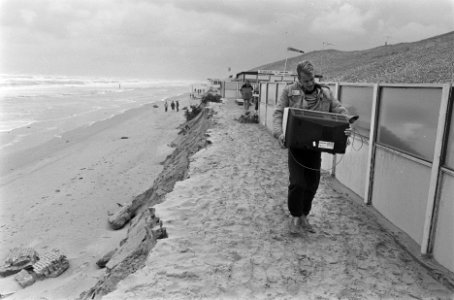 Storm verjaagt strandexploitanten exploitant redt zijn tv-toestel, Bestanddeelnr 933-7415