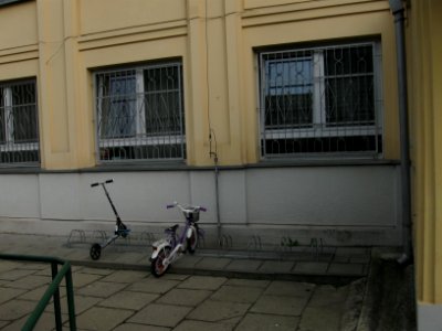 Stojaki rowerowe z hulajnogami przy szkole